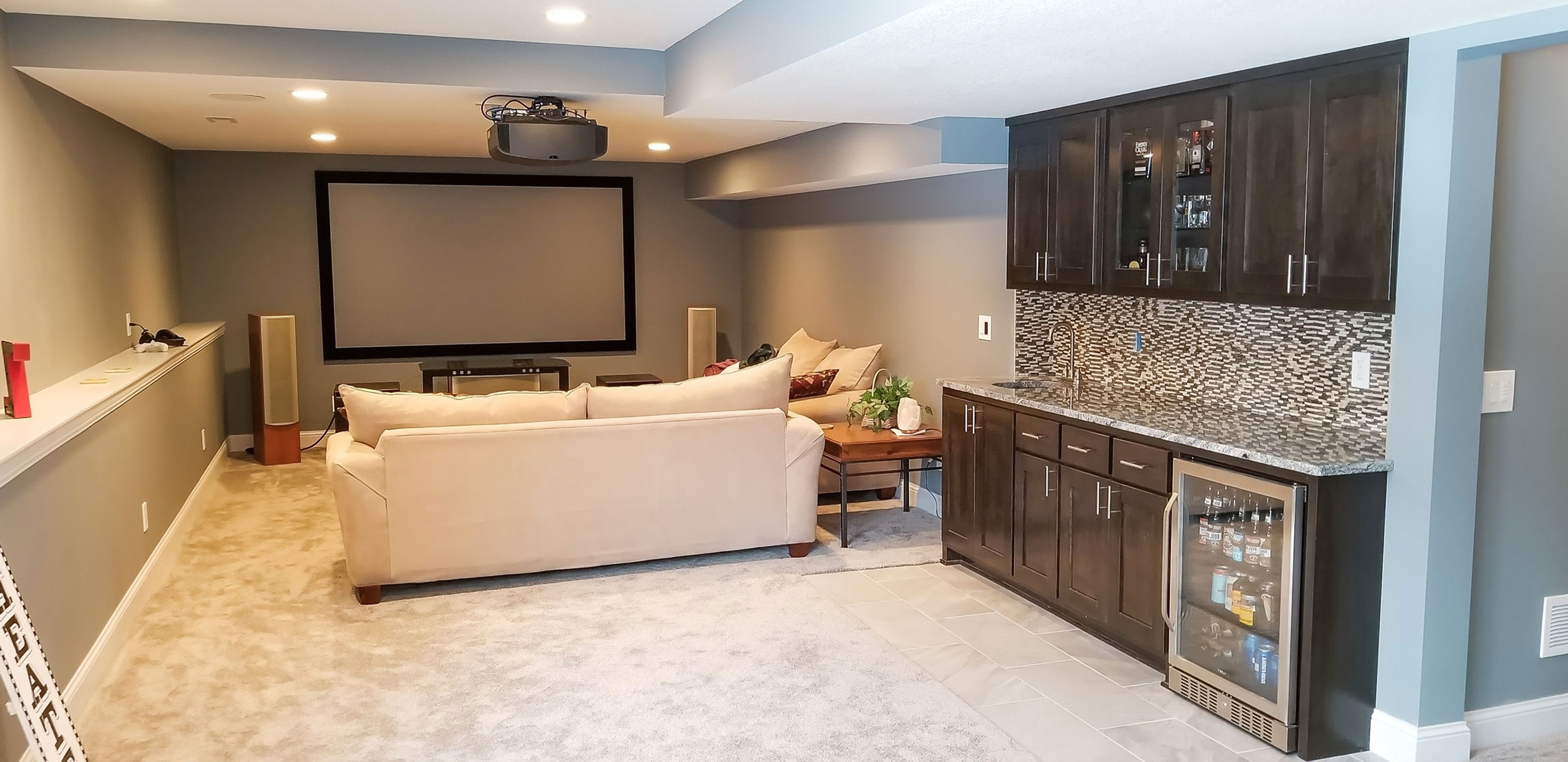 Finished basement family room with theater, wet bar, and wine fridge