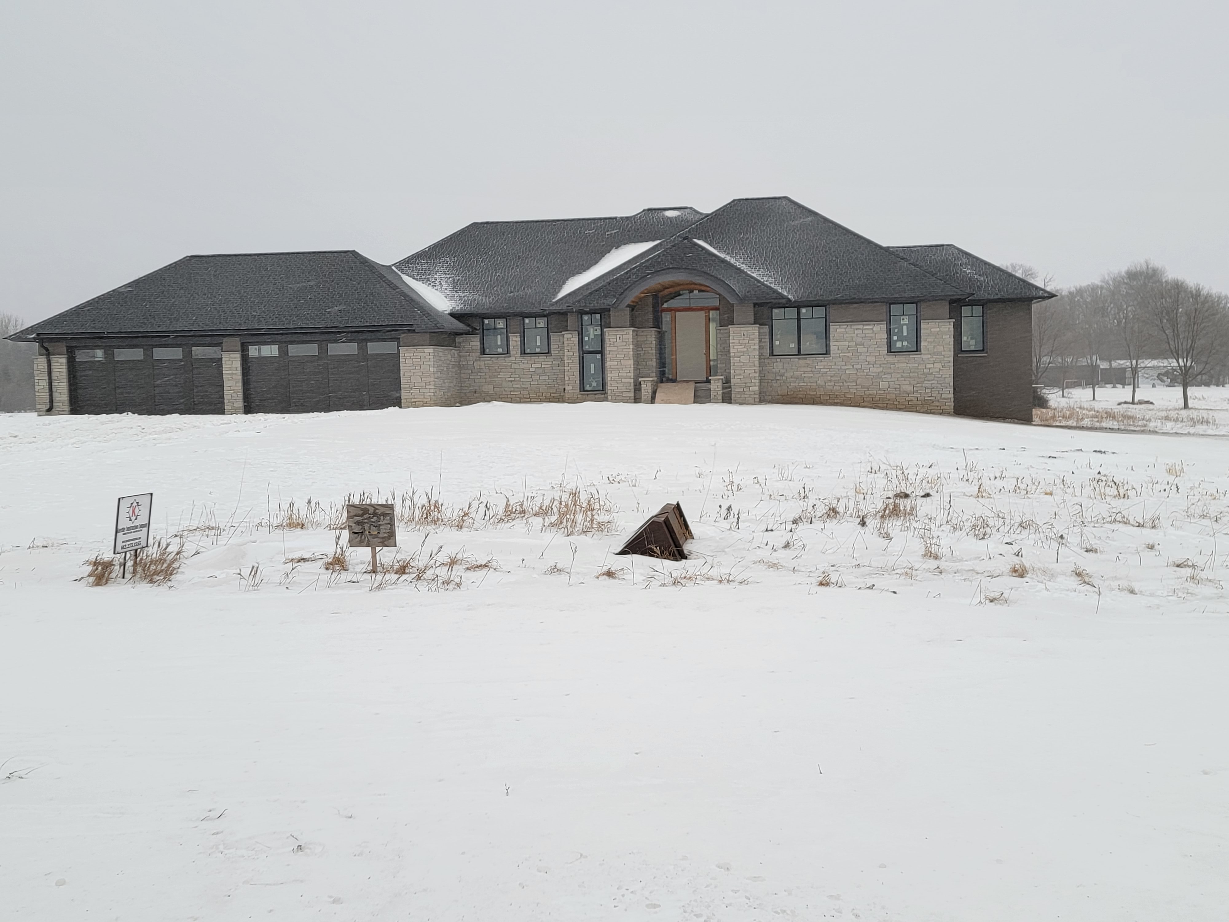 East Metro prairie custom home with stone and siding exterior in a winter setting