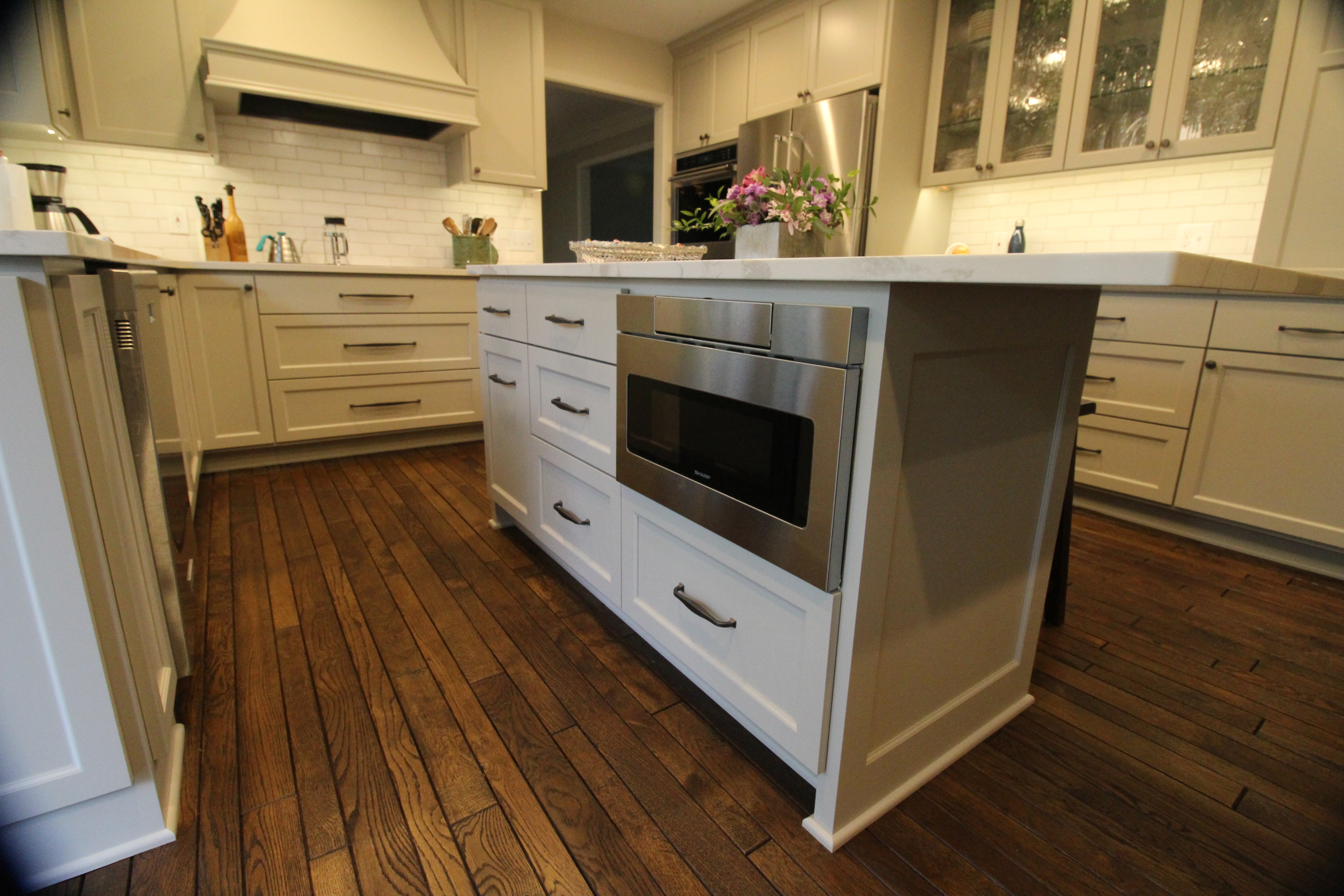 White-shaker kitchen with painted island, subway-tile backsplash, and stainless appliances