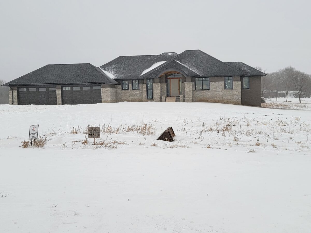 Two-story custom home exterior with stone-and-siding facade by Kuechle Construction