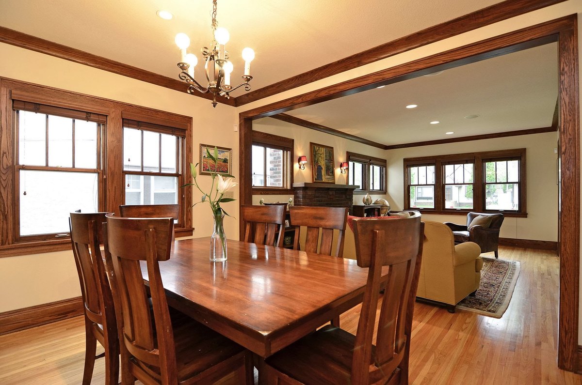 Dining room with a broad wood-trimmed opening into the living room.