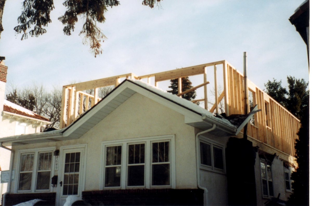 New upper-story wood wall framing above an existing enclosed porch.