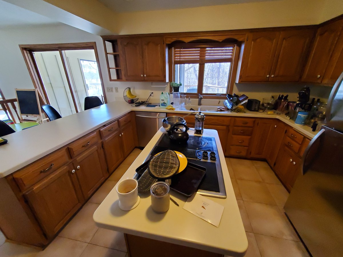 Existing wood kitchen cabinets around a central cooktop island.
