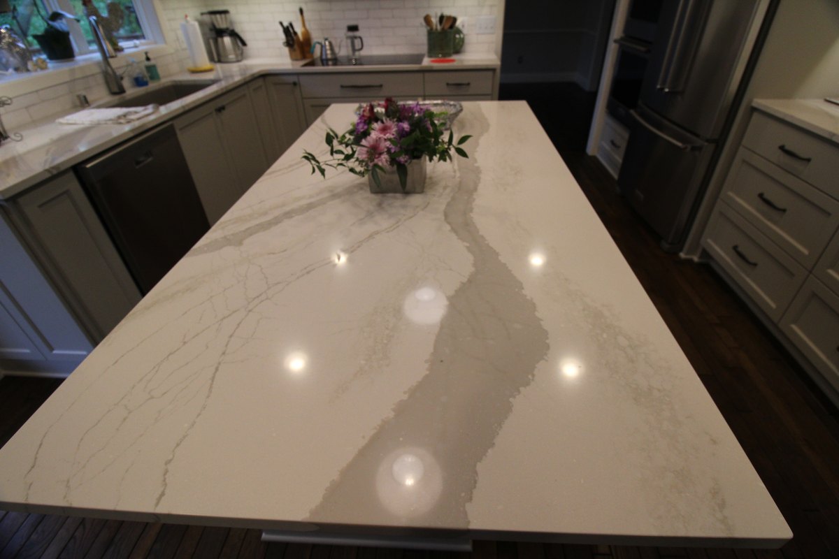Veined quartz island countertop with a floral arrangement.