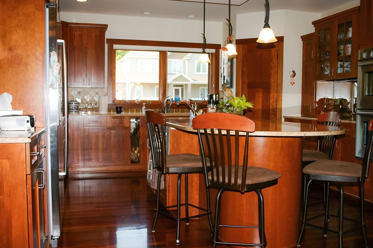 Cherry kitchen with raised island seating, pendant lighting, and dark wood floors