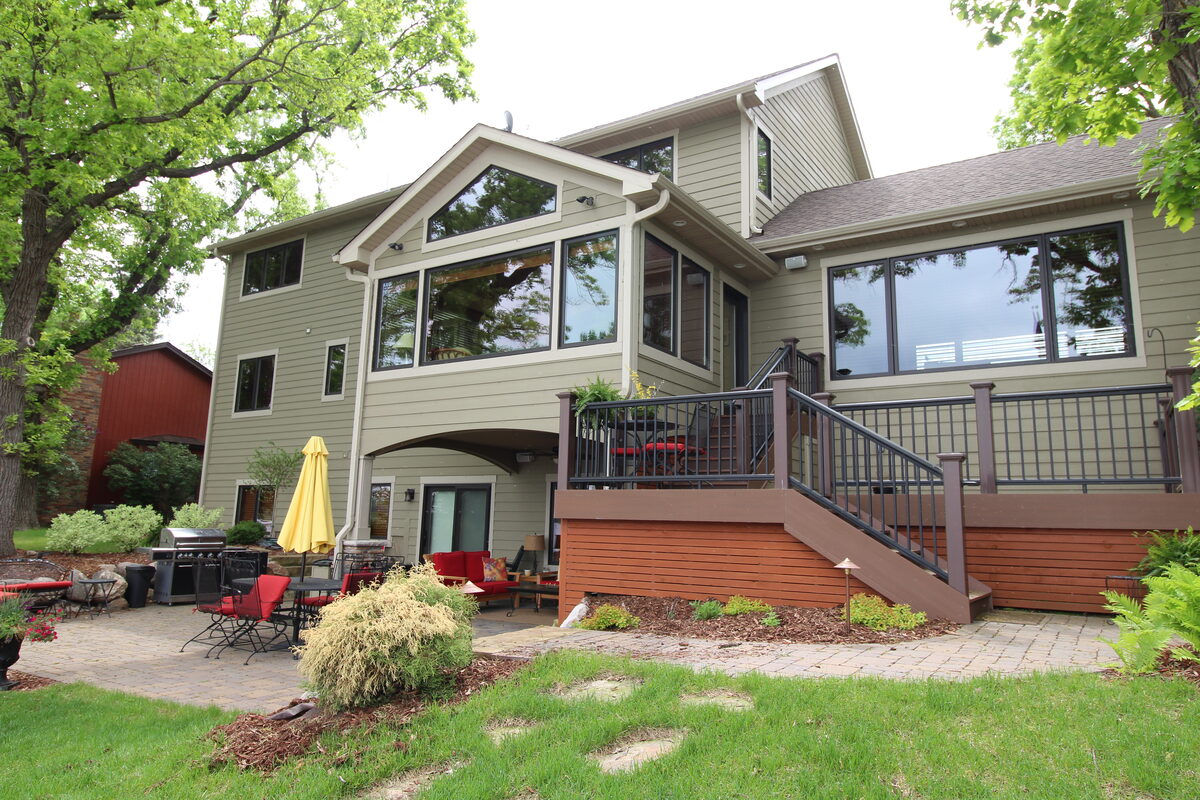 Lake-side elevation of the West Metro custom home with a tiered deck and expansive glass
