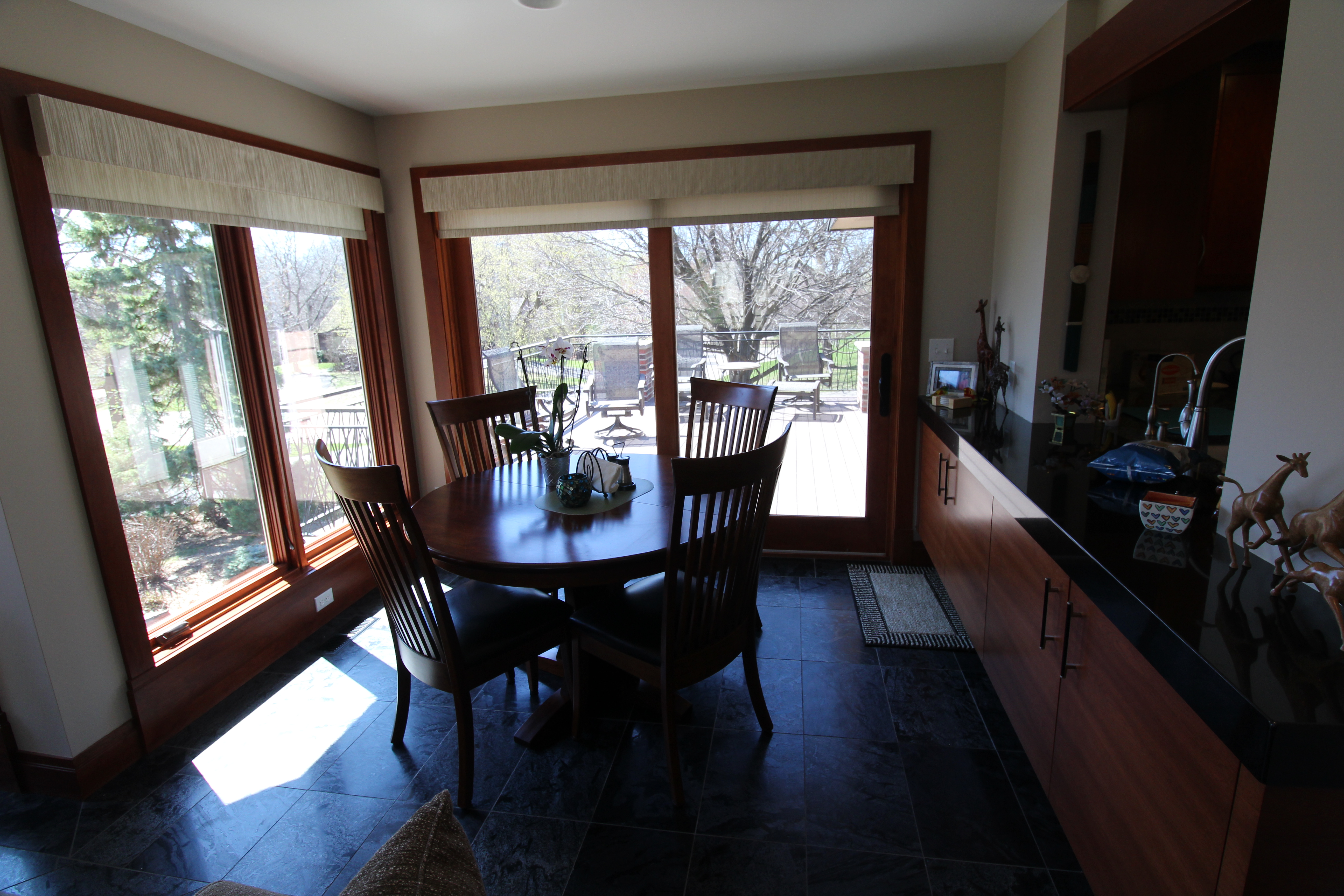 Dining nook with slate floors, dark cherry trim, and french doors to the deck